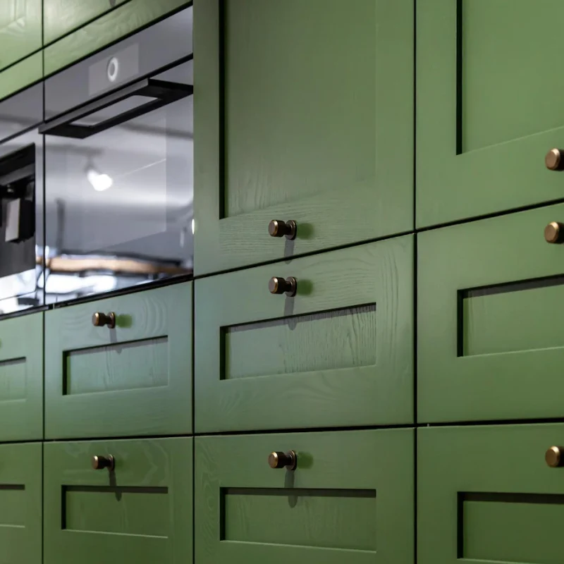 large-green-kitchen-cabinet-with-many-handles-closeup_169016-19752